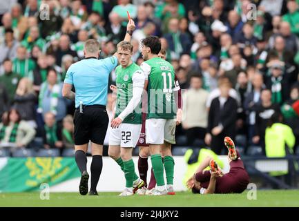 L'arbitro John Beaton mostra una cartellino rosso a Joe Newell di Hibernian per un'azione nel cuore di Peter Haring di Midlothian durante la semifinale della Scottish Cup ad Hampden Park, Glasgow. Data foto: Sabato 16 aprile 2022. Foto Stock