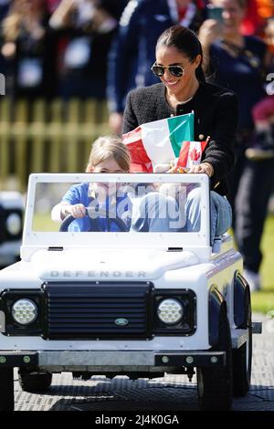 La duchessa del Sussex è guidata da un bambino in un giocattolo Land Rover alla Jaguar Land Rover Driving Challenge durante gli Invictus Games a Zuiderpark l'Aia, Paesi Bassi. Data foto: Sabato 16 aprile 2022. Foto Stock