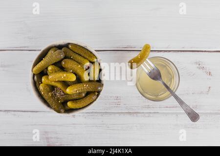 Succo sottaceto, sottaceti e cetrioli marinati in ciotola. Cibo pulito, cibo vegetariano concetto Foto Stock