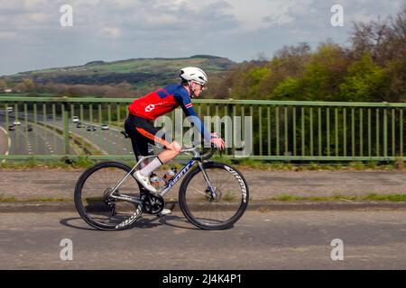 Ciclismo maschile in bicicletta da strada Giant sport su percorso di campagna attraversando il ponte autostradale in campagna Lancashire, Regno Unito Foto Stock