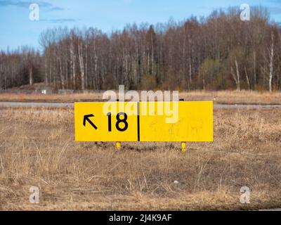 Helsinki / Finlandia - 16 APRILE 2022: Primo piano di un cartello giallo di direzione della Taziway aeroportuale. Foto Stock