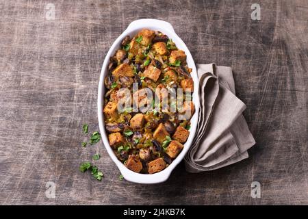 Ripieno vegano con funghi, porri e crostini croccanti su tavola di legno, vista dall'alto, orizzontale. Pasto tradizionale di ringraziamento Foto Stock