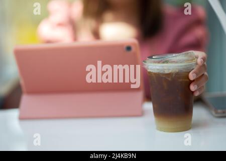 Mano donna che tiene il bicchiere di caffè ghiacciato Foto Stock