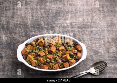 Ripieno vegano con funghi, porri e crostini croccanti su tavola di legno, vista dall'alto, orizzontale, spazio libero. Pasto tradizionale di ringraziamento Foto Stock