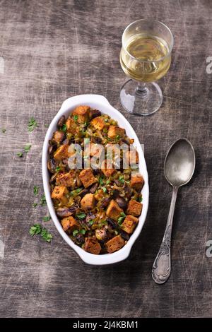 Ripieno vegano con funghi, porri e crostini croccanti su tavola di legno, vista dall'alto, orizzontale. Pasto tradizionale di ringraziamento Foto Stock