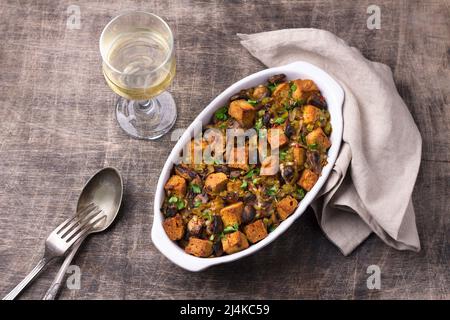 Ripieno vegano con funghi, porri e crostini croccanti su tavola di legno, vista dall'alto, orizzontale. Pasto tradizionale di ringraziamento Foto Stock