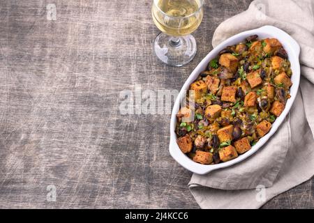 Ripieno vegano con funghi, porri e crostini croccanti su tavola di legno, spazio libero, vista dall'alto, orizzontale. Pasto tradizionale di ringraziamento Foto Stock