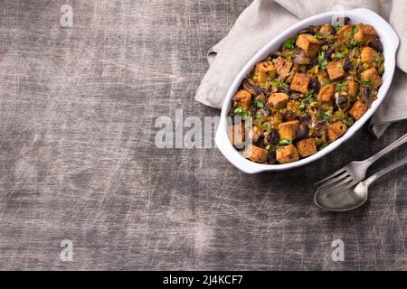 Ripieno vegano con funghi, porri e crostini croccanti su tavola di legno, vista dall'alto, orizzontale, spazio libero. Pasto tradizionale di ringraziamento Foto Stock