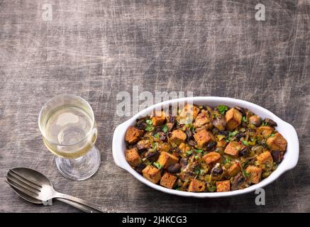 Ripieno vegano con funghi, porri e crostini croccanti su tavola di legno, spazio libero, vista dall'alto, orizzontale. Pasto tradizionale di ringraziamento Foto Stock