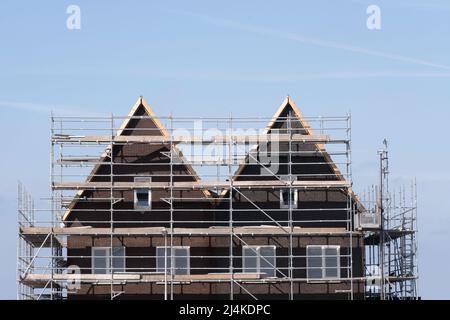 Piattaforma per impalcature contro due identiche case a schiera di nuova costruzione in un cantiere nei Paesi Bassi. Cielo blu, luogo per il testo Foto Stock
