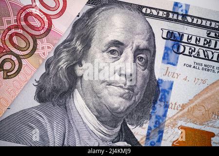 Una banconota da cento dollari e una banconota da cinquemila rubli. Primo piano. Foto Stock