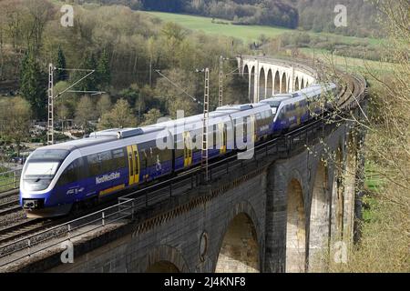 Altenbeken, Germania - Apr 13 2020 - Un treno dalla compagnia ferroviaria tedesca NordWestBahn sta accelerando un vecchio viadotto ferroviario. Foto Stock