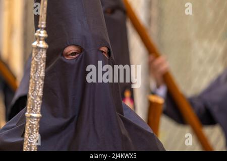 Particolare di Nazarene che tiene lunghe aste metalliche durante la processione del Venerdì Santo a Badajoz, Spagna Foto Stock