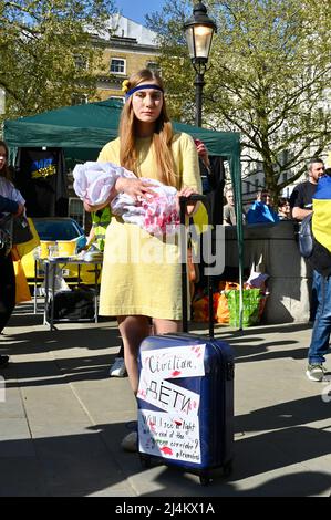 Londra, Regno Unito. I membri della comunità Ukrainain hanno partecipato ad un raduno di fronte a Downing Street per chiedere più sostegno all'Ucraina dal Regno Unito mentre la guerra con la Russia continua. Una giovane donna tiene un 'bambino' coperto di sangue falso. Ha una valigia per simboleggiare la situazione dei rifugiati che devono fuggire dall'Ucraina. Credit: michael melia/Alamy Live News Foto Stock