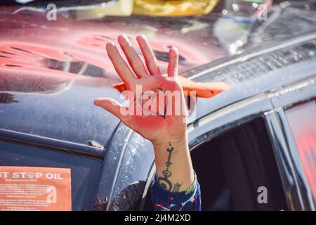 Londra, Inghilterra, Regno Unito. 16th Apr 2022. Un attivista all'interno dell'auto tiene fuori una palma coperta di vernice rossa e con un disegno di un cuore. I manifestanti di estinzione della ribellione hanno bloccato Marble Arch con una limousine. Diversi attivisti si attaccarono al veicolo, mentre centinaia di manifestanti si sedettero sulla strada. I manifestanti chiedono che il governo agisca sulla crisi climatica ed ecologica. (Credit Image: © Vuk Valcic/ZUMA Press Wire) Credit: ZUMA Press, Inc./Alamy Live News Foto Stock