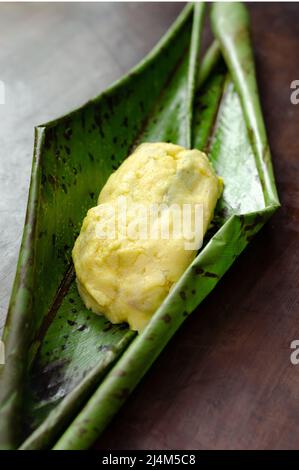 Piatto tradizionale TradioColombiano e messicano preparato con pasta di mais e ripieno di pollo, maiale, costolette di maiale, verdure, avvolto in foglie di banana, vapore. Foto Stock