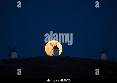 Consuegra, Spagna. 16th Apr 2022. La luna piena sorge su un mulino a vento a Consuegra, Toledo. La luna piena di aprile, conosciuta anche come Luna Rosa, quest'anno è la prima luna piena della stagione primaverile, il che significa che la Luna piena di aprile è anche la Luna piena pasquale. Credit: Marcos del Maio/Alamy Live News Foto Stock