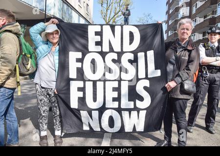 Londra, Inghilterra, Regno Unito. 16th Apr 2022. I manifestanti hanno un banner "End Fossil Fuels Now". Etienne Stott, medaglia d'oro olimpica, è salito su una petroliera Shell insieme ad un altro attivista, bloccando una strada a Bayswater, mentre diversi manifestanti della ribellione dell'estinzione hanno fornito supporto. L’atleta e l’attivista chiedono di porre fine ai combustibili fossili e chiede al governo di agire sulla crisi climatica. (Credit Image: © Vuk Valcic/ZUMA Press Wire) Credit: ZUMA Press, Inc./Alamy Live News Foto Stock