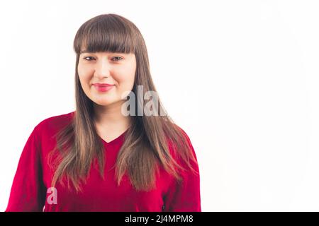 Bella donna bruna caucasica con maniche in t-shirt rossa che guarda la macchina fotografica su sfondo bianco. Scatto medio. Foto di alta qualità Foto Stock