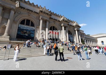 La gente cammina e si siede intorno alla grande scalinata d'ingresso al Metropolitan Museum of Art sul quinto viale in una bella giornata di primavera Foto Stock