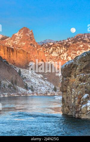 luna piena che sorge sul fiume missouri e scogliere in inverno vicino dearborn, montana Foto Stock