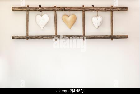 Vecchia scala in legno con cuori appesi al muro. Decorazioni per la casa. Foto Stock
