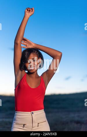 Ritratto verticale di una giovane donna nera in posa Foto Stock