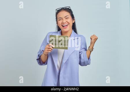 Ritratto di giovane donna asiatica allegra che mostra il libro del veicolo e celebrando la felicità isolato su sfondo bianco Foto Stock