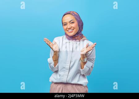 Ritratto di una giovane donna felice attraente isolato su sfondo blu Foto Stock