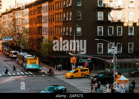 Manhattan, New York, Stati Uniti d'America: Vista ad alto angolo all'angolo tra 10th Ave e W 25th St con taxi giallo e pedoni che attraversano come visto dalla High Line Foto Stock