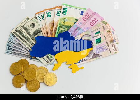 La mappa dell'Ucraina dipinta in blu e giallo si trova su banconote, dollari, euro e hryvnias su sfondo bianco. Assistenza da parte dei partner occidentali in Foto Stock