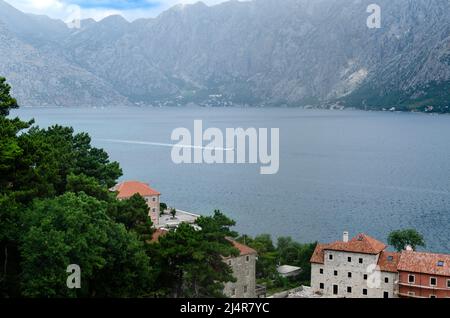 Impressionante vista aerea della parte della Baia di Cattaro - tetti rossi, alberi lussureggianti, mare e montagne Foto Stock