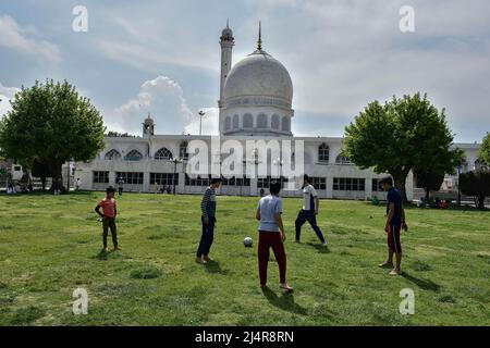 Srinagar, India. 17th Apr 2022. I ragazzi di Kashmiri giocano a calcio presso il Santuario di Hazratbal durante il mese in corso del Ramadan. I musulmani in tutto il mondo stanno segnando il mese del Ramadan, il mese più sacro del calendario islamico in cui i devoti digiunano dall'alba al tramonto. (Foto di Saqib Majeed/SOPA Images/Sipa USA) Credit: Sipa USA/Alamy Live News Foto Stock