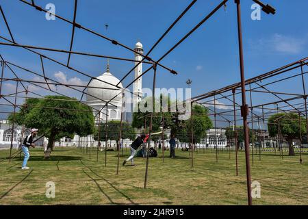 Srinagar, India. 17th Apr 2022. I ragazzi di Kashmiri giocano a cricket al Santuario di Hazratbal durante il mese in corso del Ramadan. I musulmani in tutto il mondo stanno segnando il mese del Ramadan, il mese più sacro del calendario islamico in cui i devoti digiunano dall'alba al tramonto. (Foto di Saqib Majeed/SOPA Images/Sipa USA) Credit: Sipa USA/Alamy Live News Foto Stock