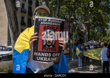 Barcellona, Spagna. 17th Apr 2022. Si vede un manifestante che mostra un cartello con una foto del presidente russo Vladimir Putin caricatured come Hitler durante la manifestazione. Centinaia di ucraini residenti a Barcellona hanno dimostrato nel centro di Barcellona di sostenere la resistenza del popolo ucraino. Credit: SOPA Images Limited/Alamy Live News Foto Stock