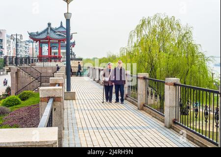 Uomo anziano e Donna che cammina fuori. Una coppia anziana, di 80 anni, che si aiutano a vicenda, braccio in braccio, sta camminando su un parco, una donna che tiene una camminata s Foto Stock