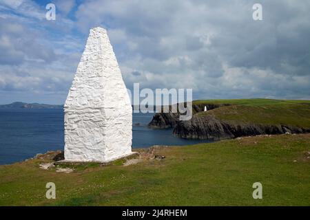 Una gabbia di pietra imbiancata che segna il porto di Porthgain, Pembrokeshire, Galles, Regno Unito. Un secondo cairn può essere visto sul Clifftop opposto. Foto Stock