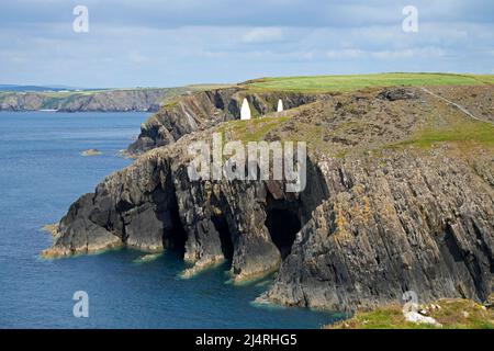 Due clifftop in pietra a distanza cairns che segna l'approccio al porto di Porthgain, Pembrokeshire, Galles, Regno Unito. Foto Stock