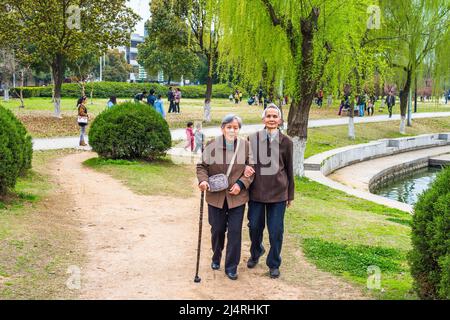 Uomo anziano e Donna che cammina fuori. Una coppia anziana, di 80 anni, che si aiutano a vicenda, braccio in braccio, sta camminando su un parco, una donna che tiene una camminata s Foto Stock