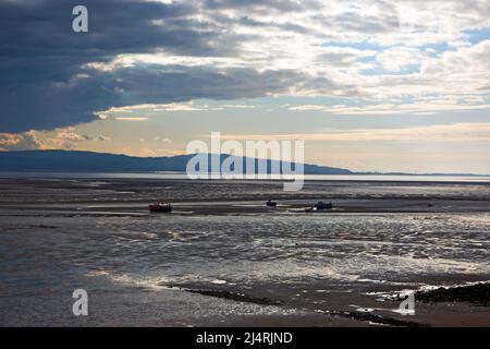 L'estuario del Dee qui visto al tramonto forma un confine tra la penisola di Wirral nell'Inghilterra nord-occidentale e il Flintshire nel Galles nord-orientale. Foto Stock