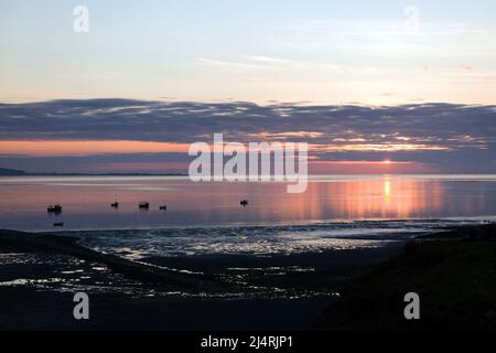 L'estuario del Dee qui visto al tramonto forma un confine tra la penisola di Wirral nell'Inghilterra nord-occidentale e il Flintshire nel Galles nord-orientale. Foto Stock