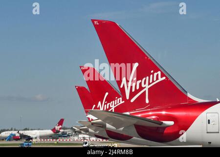 Londra, Inghilterra - Aprile 2022: Pinne di coda di Virgin Atlantic Airways Boeing Jets presso l'edificio del terminal. Foto Stock