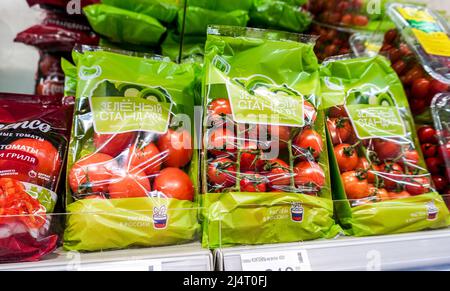 Samara, Russia - 16 aprile 2022: Pomodori freschi naturali in sacchetti di plastica sono venduti su uno scaffale in un negozio Foto Stock