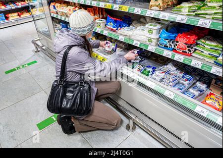 Samara, Russia - 16 aprile 2022: Donna che sceglie i prodotti lattiero-caseari in un negozio di alimentari Foto Stock