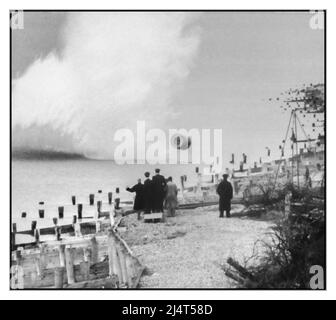 DAMBUSTERS. BOUNCING BOMB Operation CHASTISE: The Attack on the Moehne, Eder and Sorpe Dams by No. 617 Squadron RAF nella notte del 16/17 maggio 1943. No. 617 Squadron pratica lanciando l'arma della "bomba rimbalzante" al campo di bombardamento di Reculver, Kent. Un gruppo di osservatori osserva mentre la bomba rimbalza verso la costa. Il dottor Barnes Wallis, l'inventore, all'estrema sinistra del gruppo, può essere visto sollecitare la bomba a salire con il braccio sollevato. Seconda guerra mondiale seconda guerra mondiale Foto Stock