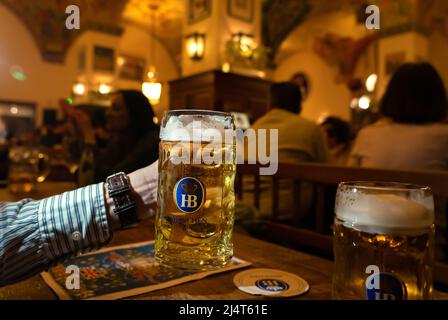 Monaco di Baviera, Germania - 04.07.2022: Famoso hofbrauhaus tradizionale pud keller a Monaco di Baviera uomo che tiene HB birra brocca Krugel Foto Stock