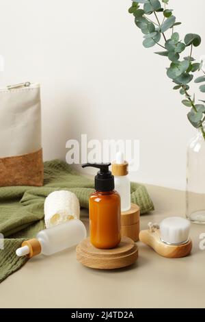 Prodotti cosmetici Natural SPA con foglie di eucalipto e asciugamano verde. Flacone dispenser sapone liquido su piattaforma in legno, flaconi contagocce in vetro, corpo Foto Stock
