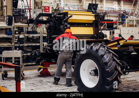I lavoratori industriali assemblano la trebbiatrice agricola in officina. Foto Stock