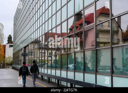 Aarau, Svizzera - 3 novembre 2021: Riflessioni delle case di Aarau nella superficie di vetro dell'edificio moderno. Foto Stock