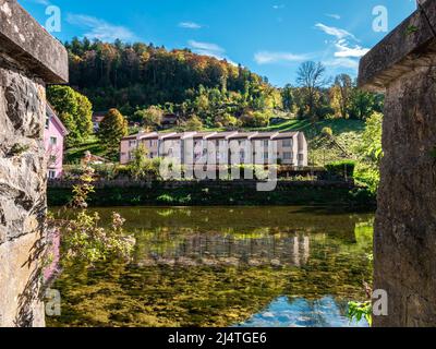 Saint Ursanne, Svizzera - 19 ottobre 2021: Case residenziali a schiera sulle rive del fiume Doubs a Saint Ursanne in autunno Foto Stock